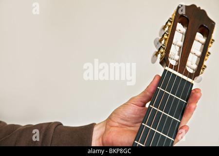 Cordes guitare classique close up avec la main gauche tenant le manche de cou Banque D'Images