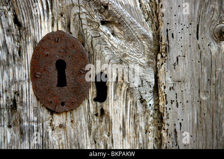 Trou de serrure sur de vieux bois gris, métal rouillé Banque D'Images