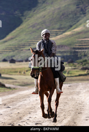 Un homme à cheval le long d'une route poussiéreuse dans les hautes terres du Lesotho Banque D'Images