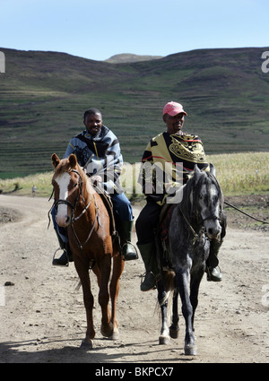 Horsees locaux hommes installés le long d'une route poussiéreuse dans les hautes terres du Lesotho Banque D'Images