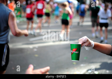 MARATHON DE CHICAGO ; l'UN DES MEMBRES DU PERSONNEL DU MARATHON DE CHICAGO DE REMETTRE UNE TASSE DE BOISSON ÉNERGÉTIQUE À UN COUREUR Banque D'Images