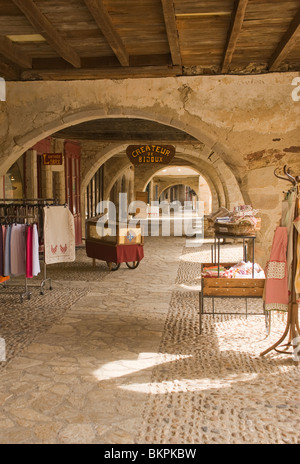 Allée voûtée en pierre couvert historique avec des magasins au Market Square de Sauveterre-de-Rouergue Aveyron Midi-Pyrénées France Banque D'Images