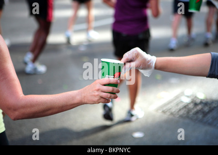 MARATHON DE CHICAGO ; l'UN DES MEMBRES DU PERSONNEL DU MARATHON DE CHICAGO DE REMETTRE UNE TASSE DE BOISSON ÉNERGÉTIQUE À UN COUREUR Banque D'Images