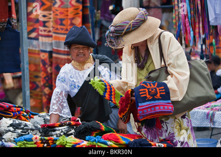 L'Équateur, un touriste achète des chapeaux de laine du marché d'Otavalo à femme équatorienne. Banque D'Images