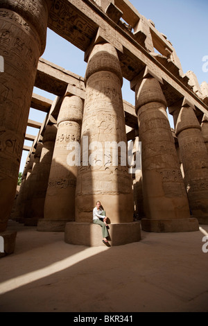 Egypte, Karnak. Un touriste se trouve à la base d'une colonne en pierre massive dans la salle hypostyle. (MR) Banque D'Images