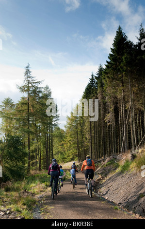 Circuit à vélo en famille le long de la manière, au bord du lac Kielder Water & Forest Park, Northumberland, Angleterre. Banque D'Images