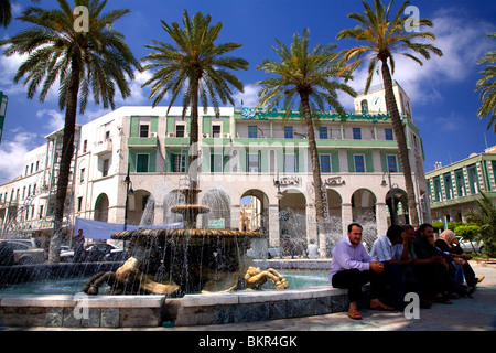 La Libye, la Tripolitaine ; Tripoli ; les gens assis près de la fontaine à la fin de la Place Verte, la place principale à l'extérieur de la Vieille Ville Banque D'Images