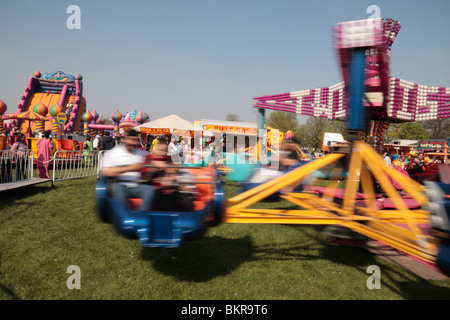 Vue floue de cavaliers sur un champ de foire de spinning ride à une fête foraine dans Lampton Park, London, West London, 2010 Banque D'Images