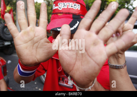 Un chandail rouge manifestant ne veut pas être photographié au cours des manifestations anti-gouvernement à Bangkok, Thaïlande. Banque D'Images