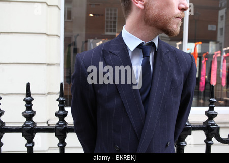 Un tailleur assistant se place en dehors de Richard James shop à Savile Row, Londres. Banque D'Images