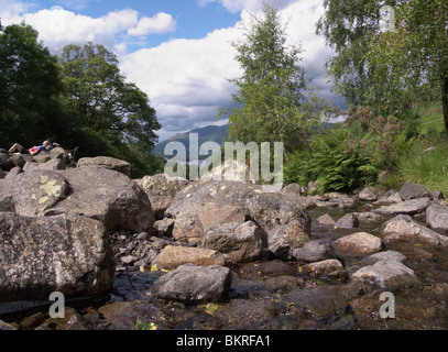 Un cycliste se reposant à Ashness Pont dans le parc national de Lake District en Cumbrie, donnant sur Derwent water avec Skiddau derrière Banque D'Images