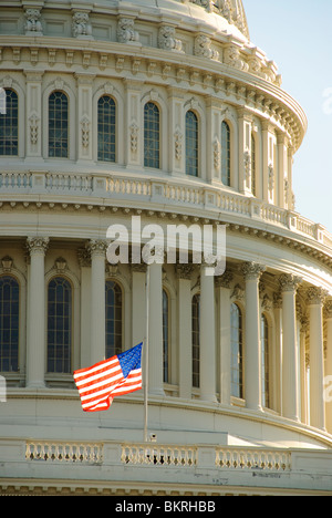 Drapeau du dôme du Capitole des États-Unis à la moitié de l'état-major Washington DC // WASHINGTON DC, États-Unis — le dôme du Capitole des États-Unis s'élève bien en évidence contre le ciel, avec un drapeau américain qui flotte à la moitié de l'état-major au premier plan. Le Capitole, siège du Congrès américain, sert de siège à la branche législative du gouvernement fédéral. La position du drapeau à mi-état-major indique une période de deuil national ou de commémoration, suite à une proclamation présidentielle ou à une directive du Congrès. Le bâtiment néoclassique, achevé en 1800 avec son dôme emblématique ajouté en 1866, se dresse comme l'un des Mo Banque D'Images