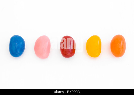Cinq jelly beans dans une ligne sur un fond blanc Banque D'Images