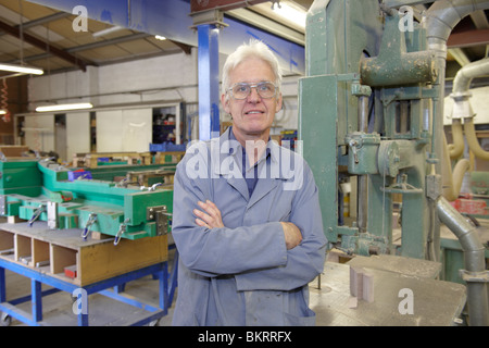 Portrait of senior travailleur à l'usine à côté de machine Banque D'Images