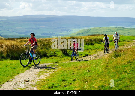 Groupe familial en vtt sur Stockdale Lane près de régler, une partie de l'encadrement vtt boucle vélo, Yorkshire Dales Banque D'Images