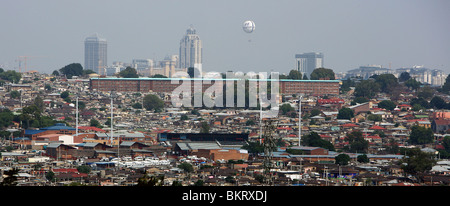 Regardez par-dessus sur Alexandra Township de Sandton City district de luxe dans l'arrière-plan avec ses hôtels et centres commerciaux Banque D'Images