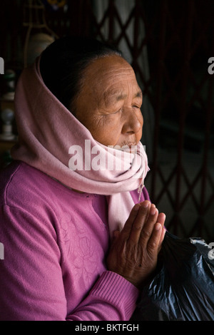 Une fervente bouddhiste tibétain dans la prière à BODHANATH STUPA - Katmandu, Népal Banque D'Images