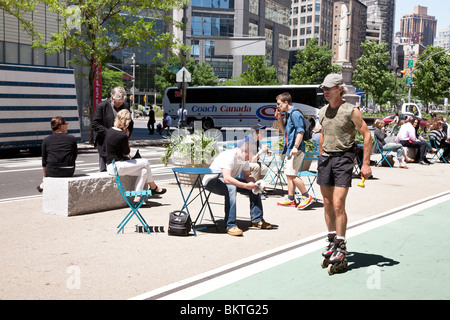 Roller homme public coin salon en plein air passe sur Broadway à Columbus Circle, sur une belle journée de printemps à Manhattan NYC Banque D'Images