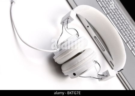 L'élégance et l'ordinateur portable casque blanc sur fond blanc, sur l'inclinaison. Banque D'Images