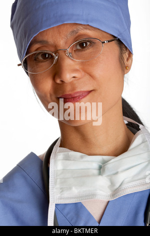 Portrait de gros plan femme asiatique un professionnel médical portant des gommages et sourire vers la caméra. Tir vertical. Isolées. Banque D'Images