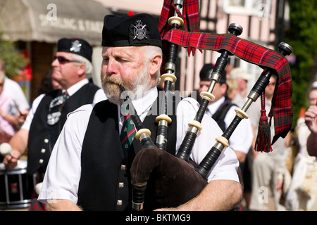 Un pipe band de tarten kilts participant à la banque août holiday parade grâce à Lavenham Banque D'Images