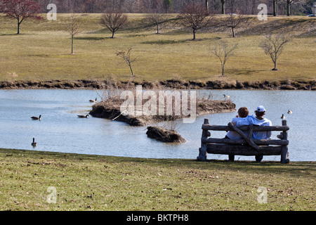 Jeune couple assis sur un banc en bois dans le jardin public vue arrière photos images Grande haute résolution horizontale aux États-Unis haute résolution US haute résolution Banque D'Images