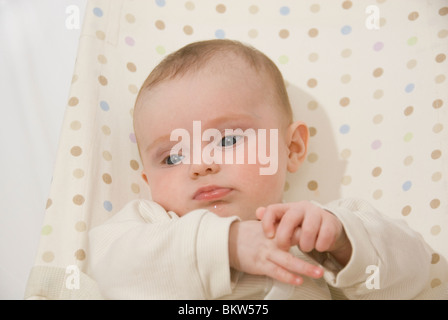 Gros plan sur le visage et les mains de Baby Girl Sitting in repéré en videur Président Banque D'Images