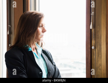 Businesswoman looking out par la fenêtre Banque D'Images