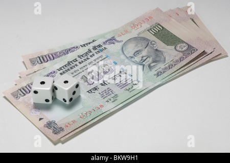Deux dés sur le dessus de 100 billets de roupie indienne Banque D'Images