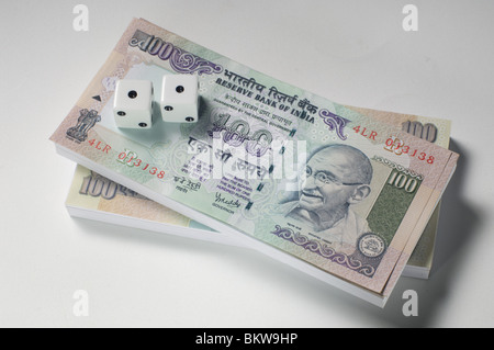 Deux dés sur le dessus de 100 billets de roupie indienne Banque D'Images