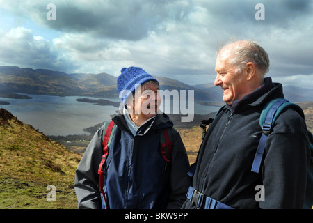 Personnes âgées actives rendez la randonnée dans le Parc National des Trossachs, Ecosse Banque D'Images