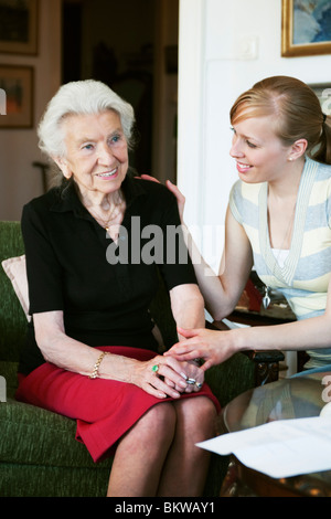 Deux femmes parler sitting in armchair Banque D'Images