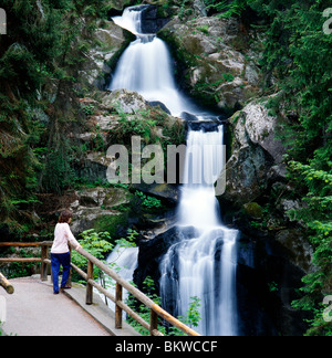 L'affichage touristique féminine Cascades de Triberg, chutes d'eau plus élevée en Allemagne (Forêt Noire). Banque D'Images