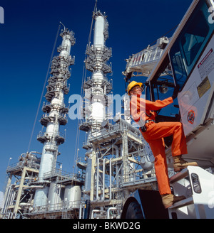 Worker climbing dans un camion à une raffinerie de pétrole dans la région de Delaware, Etats-Unis Banque D'Images