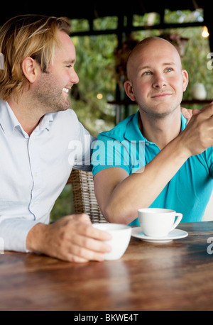 Deux gay men sitting by table Banque D'Images