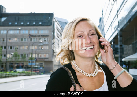 Laughing businesswoman talking in cellphone Banque D'Images