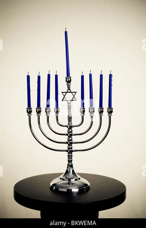 Une Menorah se tient sur une table. L'image a été manipulé pour le faire paraître vieux. Banque D'Images