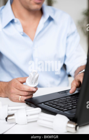 Homme avec ordinateur portable et ampoules Banque D'Images