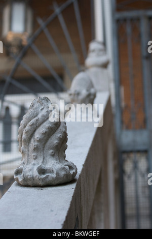 Fleuron en pierre taillée en forme d'une pieuvre sur une balustrade de pierre dans le marché du Rialto avec porte en fer forgé à Venise Banque D'Images