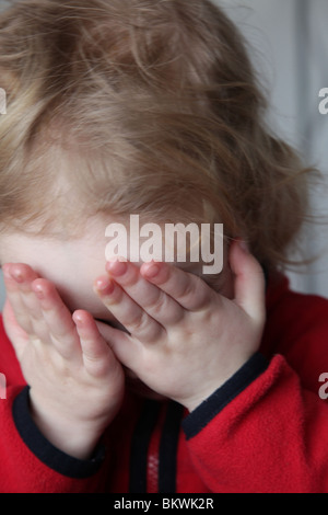 Enfant de deux ans baby girl jouer joue à cache-cache modèle jeu libéré Banque D'Images