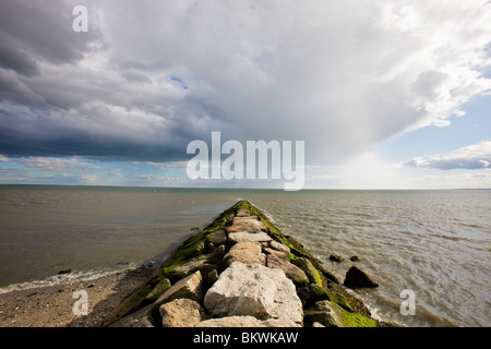 Averses de pluie dans la distance comme vu à partir d'un brise-lames sur Long Beach à Stratford (Connecticut) à côté de Wildlife Refuge Banque D'Images