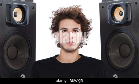 Studio portrait d'un jeune homme de race blanche à l'écoute de musique avec haut-parleur isolé sur fond blanc Banque D'Images