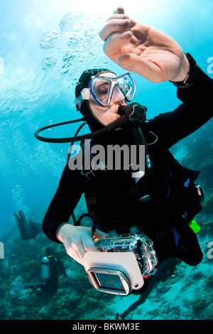 Scuba Diver avec son appareil photo de plongée montre lors de sa vérification de la butée de sécurité Banque D'Images