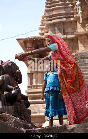 Les femmes de l'Inde et sa fille adorant Ganesh statue. Temple Matangesvara. Khajuraho. L'Inde Banque D'Images