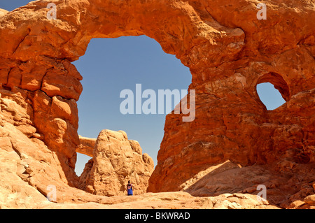 Stock photo d'un homme en chemise bleu permanent, sous tourelle Arch dans Arches National Park Utah, USA. Banque D'Images