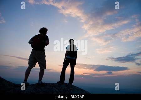 Un couple regarde le coucher du soleil sur le sommet du mont Monadnock dans Monadnock State Park à Jaffrey, New Hampshire. Banque D'Images