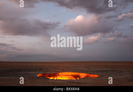 Derweze ou Darvaza, alias comme la porte de l'enfer est un énorme cratère de la combustion de gaz naturel dans le désert de Kara kum au Turkménistan. Banque D'Images