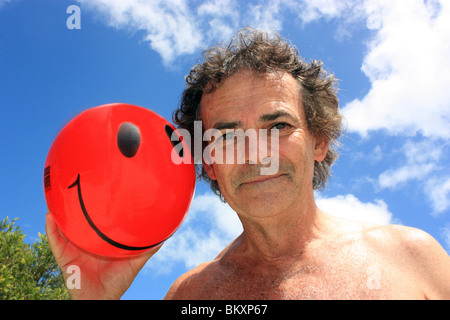 Cinquante-CINQ ANS AVEC SMILEY ROUGE BALLE CONTRE CIEL BLEU BDA Banque D'Images