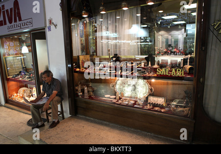 Une bijouterie keeper de lire le journal dans le Grand Bazar d'Istanbul, la capitale de la Turquie. Banque D'Images