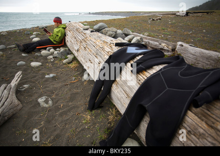 Un homme lit un livre au camp sur la côte perdue, en Californie. Banque D'Images